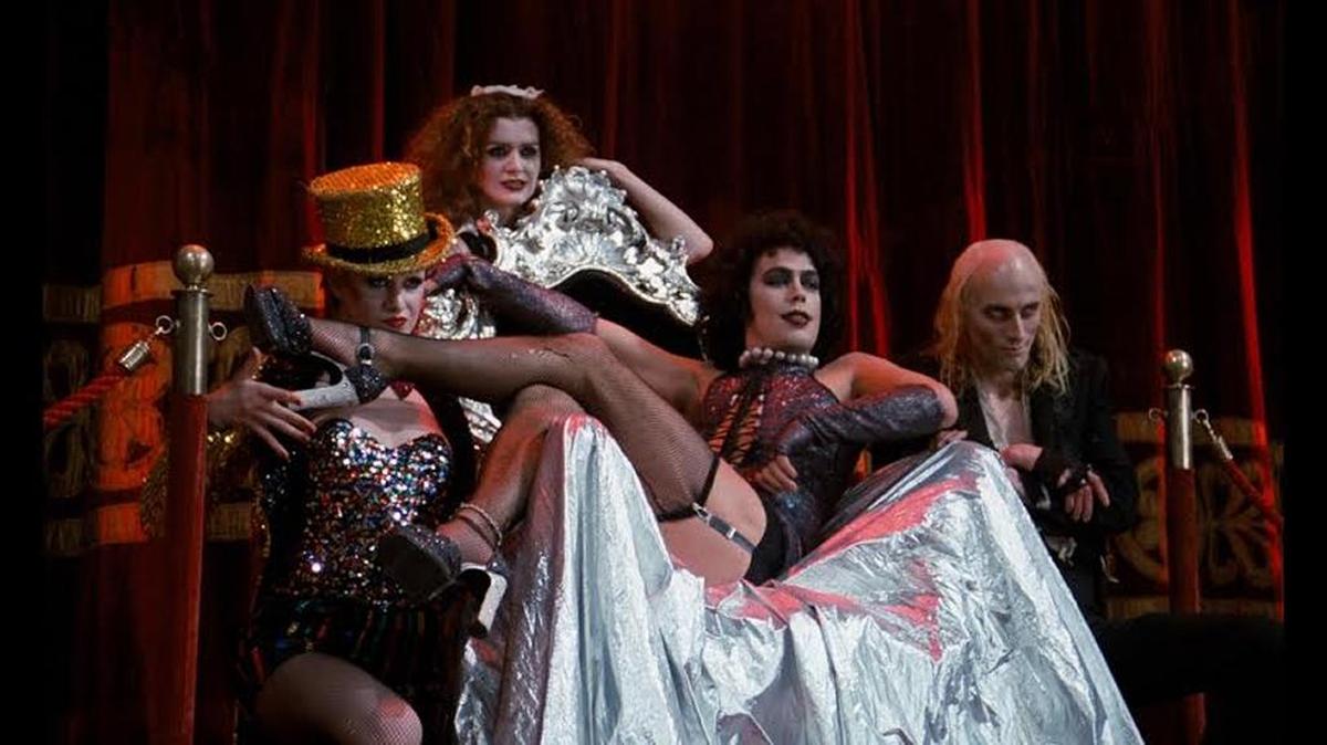 Dr. Frank-N-Furter (Tim Curry, center) presides over all kinds of delirious weirdness in ‘The Rocky Horror Picture Show.’
