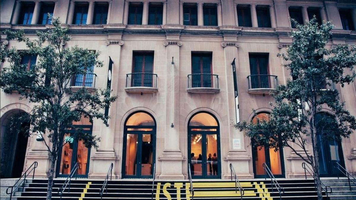 
Outside, by MCAD’s front steps, an audio installation features narratives of people describing attributes of each of the exhibit’s ten featured downtown buildings; it’s accompanied by a large, vinyl floor applique inviting the passersby to “LISTEN” to the building.
