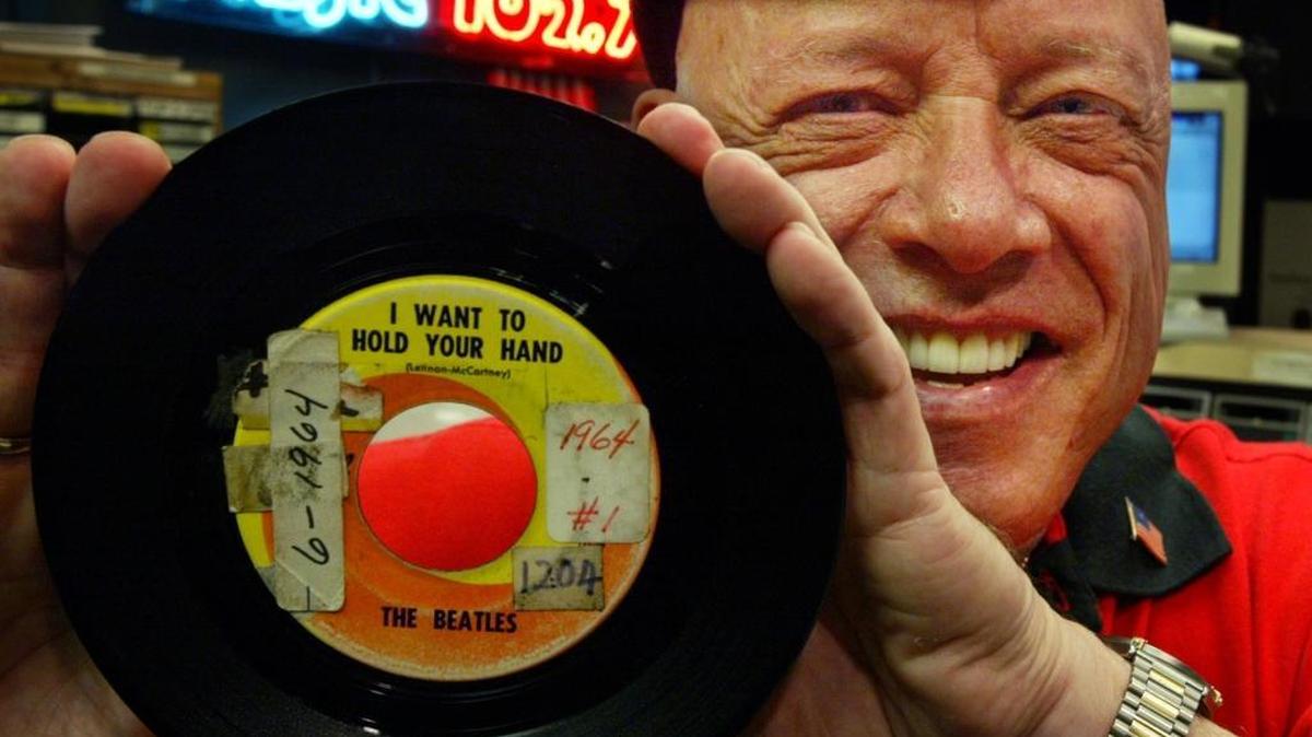 DJ Rick Shaw holds up the original 45 of the first Beatles hit he played on South Florida radio, “I Want to Hold Your Hand,” in 1964. While at Majic 102.7 in 2004, he celebrated its anniversary.