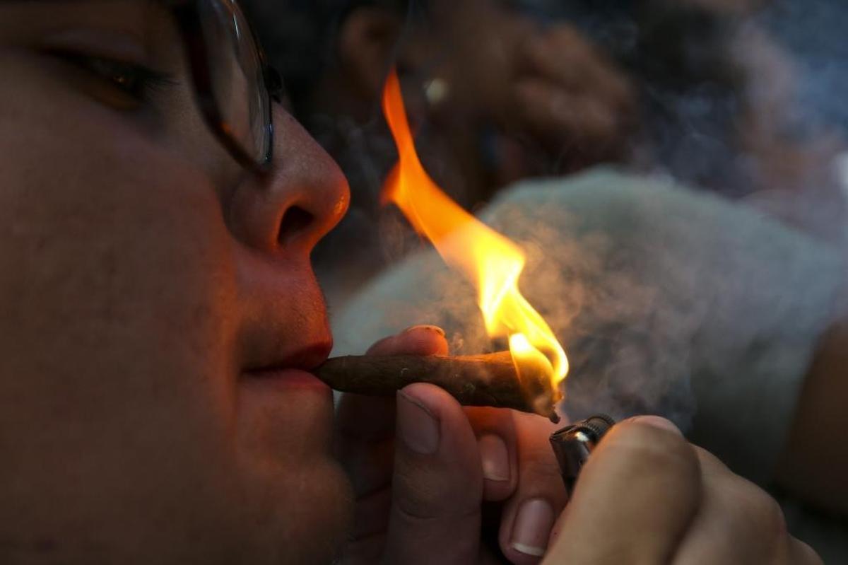Robert Whitaker, 18, from Hammond, Louisiana, lights a joint while Curren$y performs during the first day of the Rolling Loud Festival in downtown Miami on Fri., May 5, 2017.