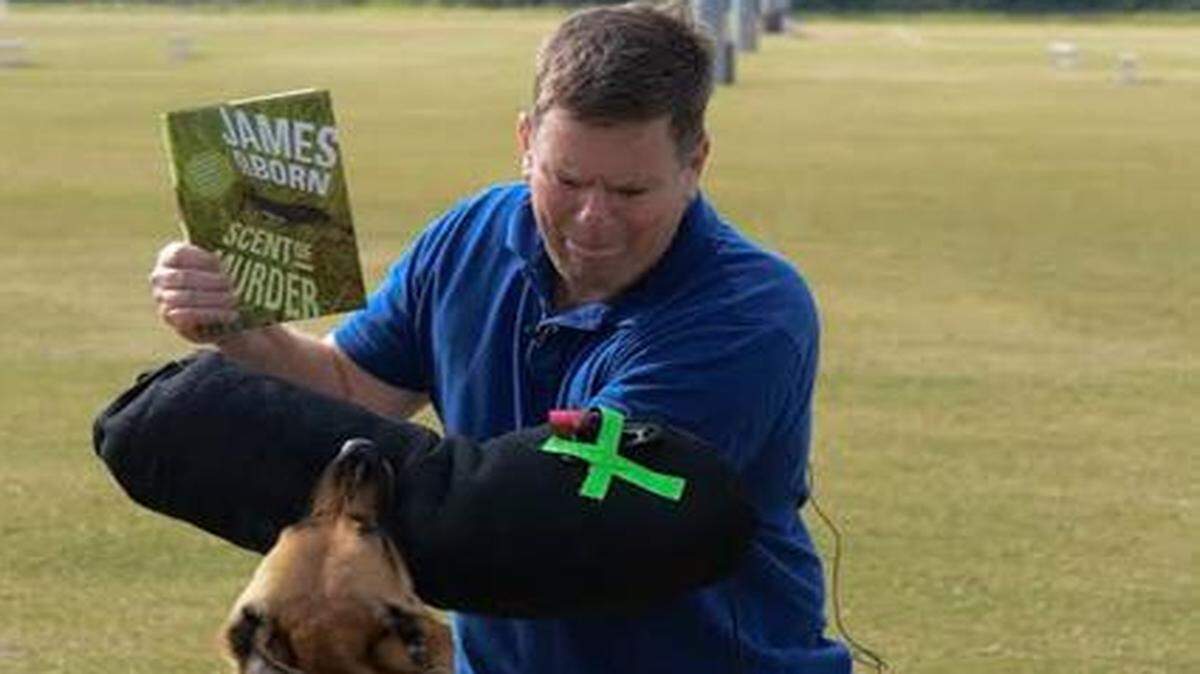 
Book with a bite: James O. Born gets a taste of what a police dog can do when he tangles with Jimi of the K-9 unit for the Jupiter Police Department. “All I could think when it was over was ‘Thank God he didn’t tear my rotator cuff!’ ” Born says.
