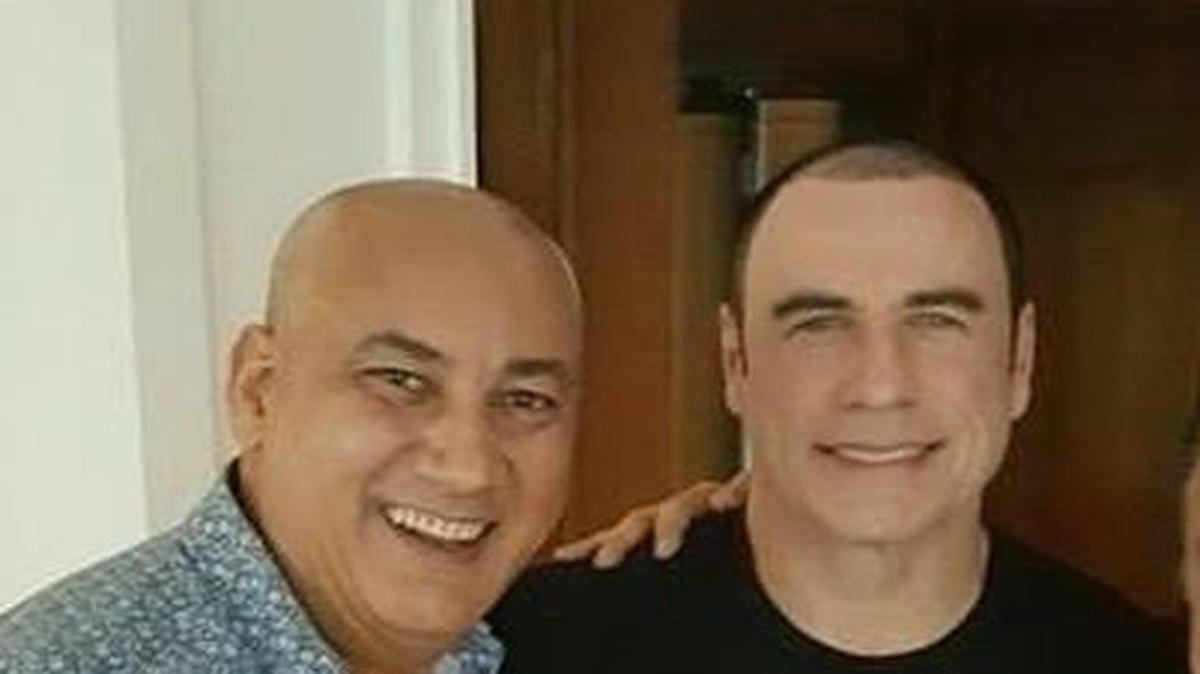 John Travolta poses for a selfie with onlookers at Palmeiras Beach Club at Grove Isle