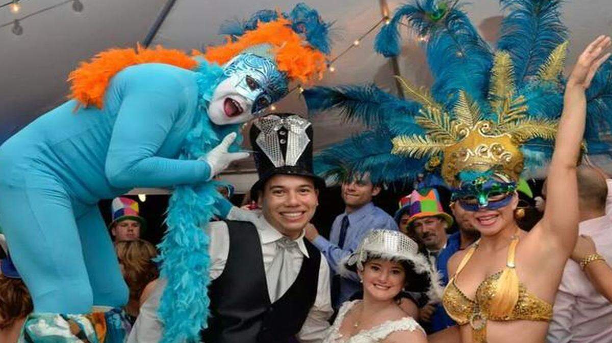 
Mariana Rodriguez and Jose Hurtado with two of Black & Wine Events’ performers for “La Hora Loca” at their wedding. 
