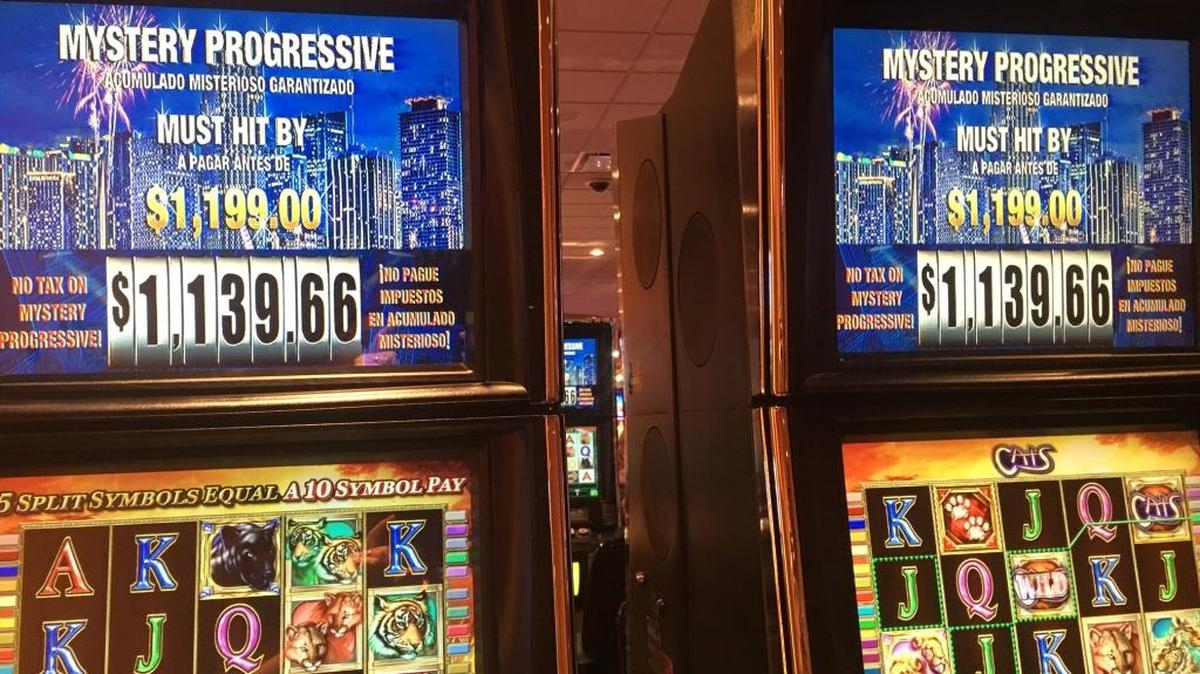 Banks of machines at Magic City and Dania casinos promote Mystery Progressives.