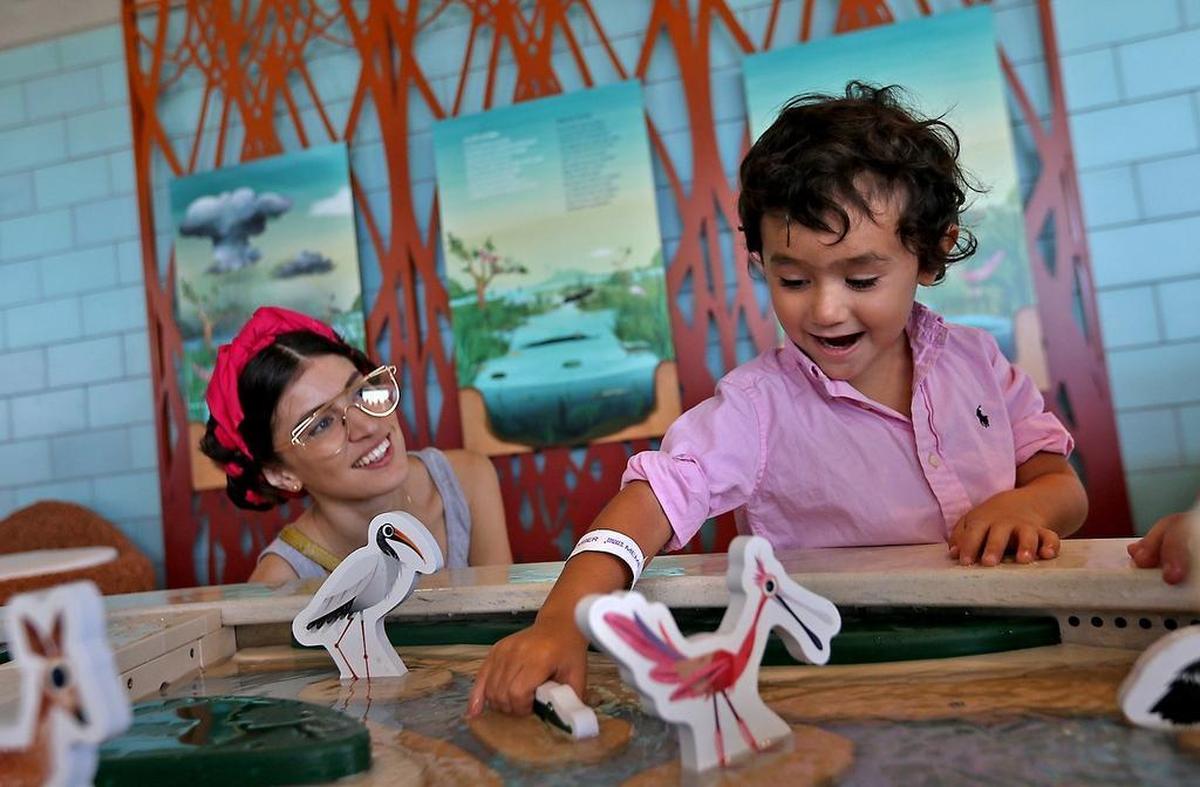 Dominic Guillant, 3, plays with an interactive exhibit as Danié Gomez-Ortigoza looks on during the long-awaited opening of the Phillip and Patricia Frost Museum of Science on Sunday, May 7, 2017.