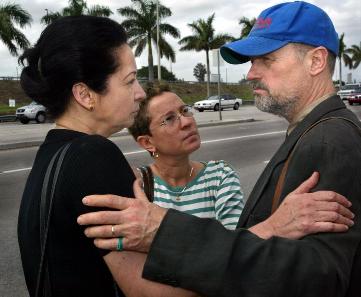Haitian journalists Michel Montas-Dominique (left) and Jan Dominique (center) greet Jonathan Demme after the three visited detained Haitian families at the Krome Detention Center on Feb. 23, 2003. Montas-Dominique and Demme spoke to the media briefly about the conditions of the Haitian detainees.