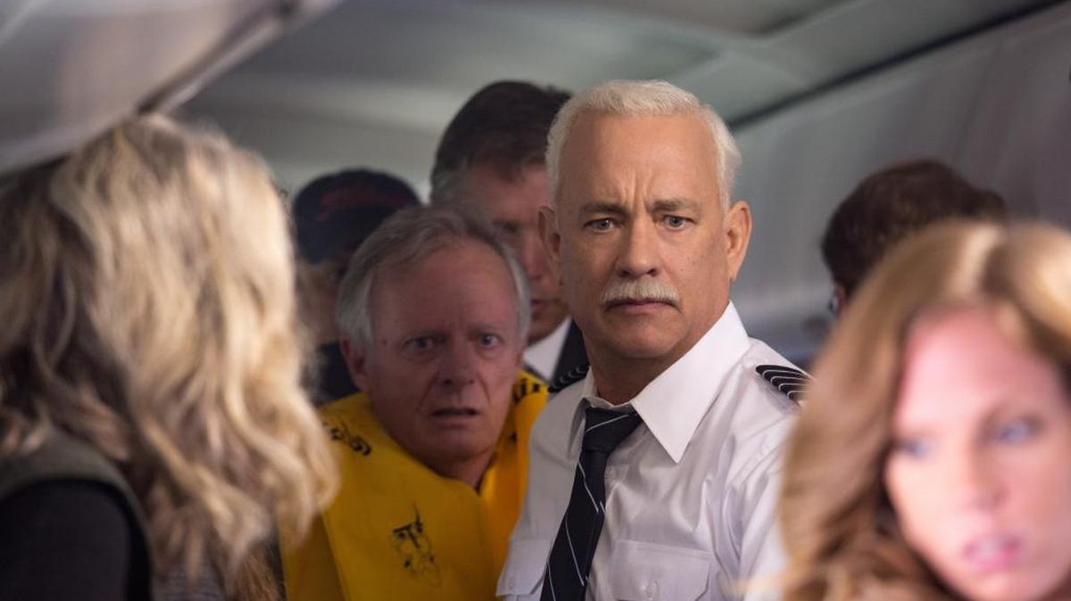 Capt. Chesley Sullenberger (Tom Hanks) helps passengers evacuate a crippled plane in ‘Sully.’