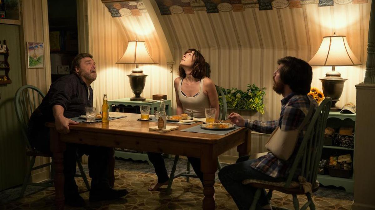 (l. to r.) John Goodman, Mary Elizabeth Winstead and John Gallagher Jr. form an uneasy family in ‘10 Cloverfield Lane.’