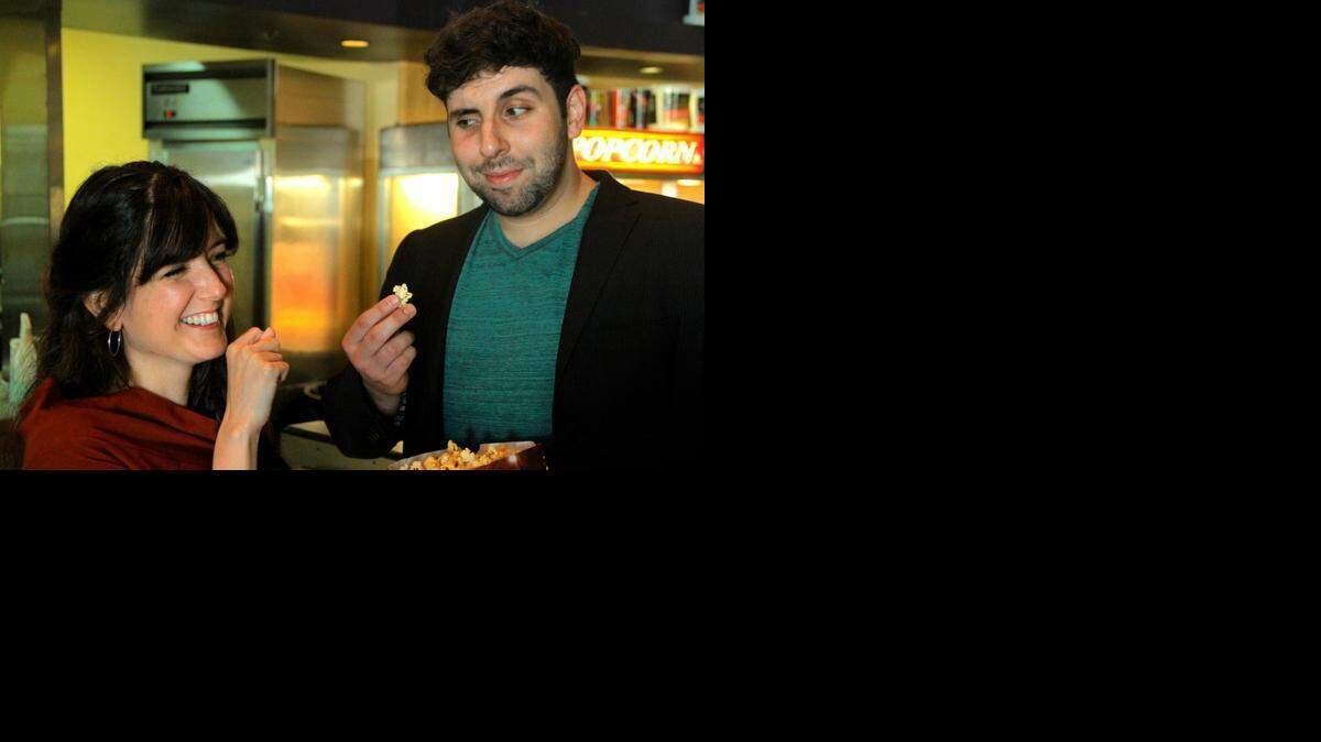 
‘El Mago’ executive producer Ana Rodriguez, left, and director David Liz, right, enjoy some popcorn and jokes at the Hialeah Muvico Theater on Wednesday, March 4.
