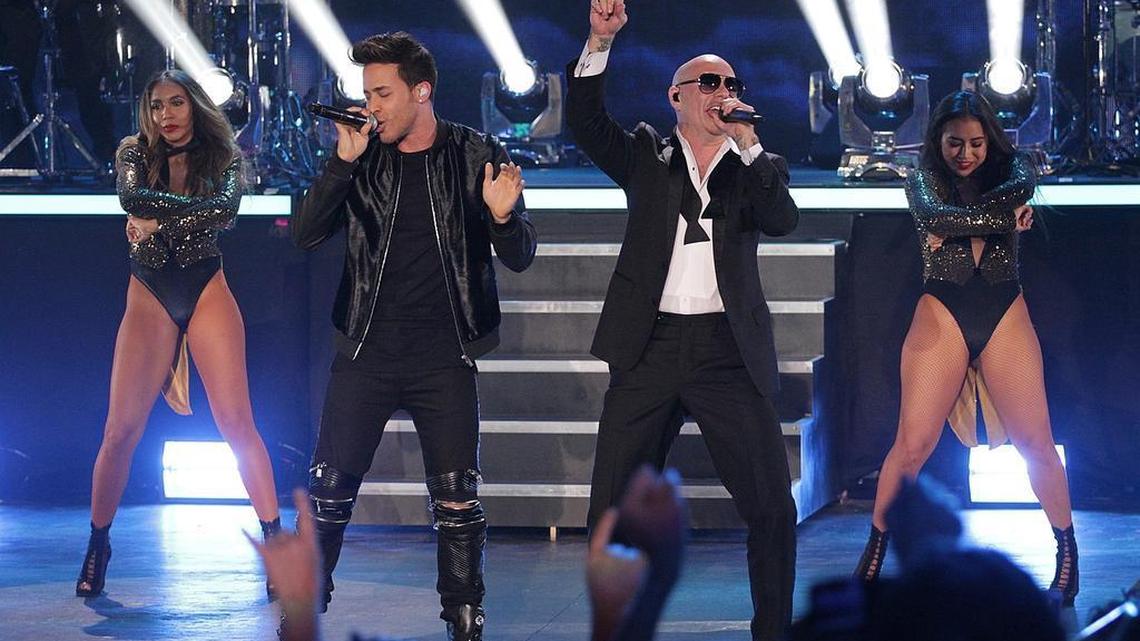 Recording artists Pitbull, center right, and Prince Royce, center left, perform on stage with dancers at Bayfront Park on New Year’s Eve last year. Pitbull is one of the few current artists who have achieved major success in the U.S. and in Latin music industries.