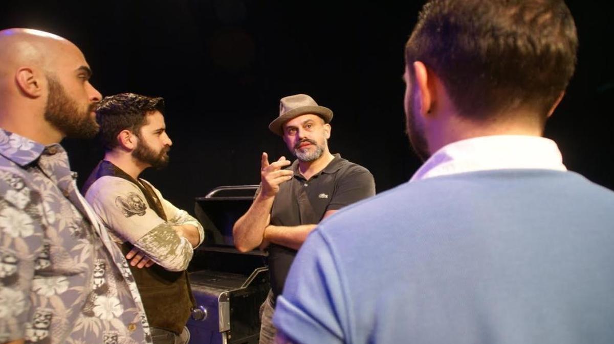 Ricky J. Martinez (center, in hat) talks to actors Gabriel Bonilla, David Vega and Mikey Fernandez during rehearsals for the New Theatre world premiere of his play ‘Roof!’