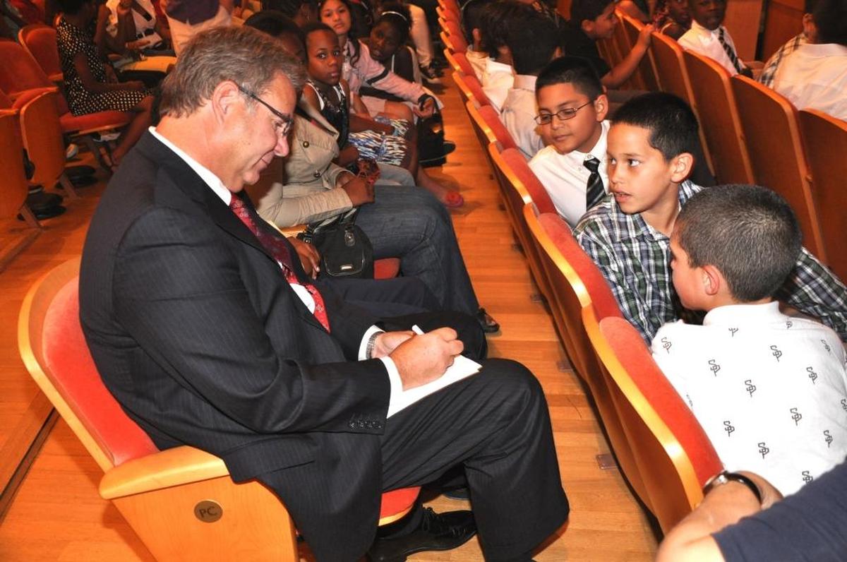 Arsht Center President and CEO John Richard signs an autograph for children in the audience.