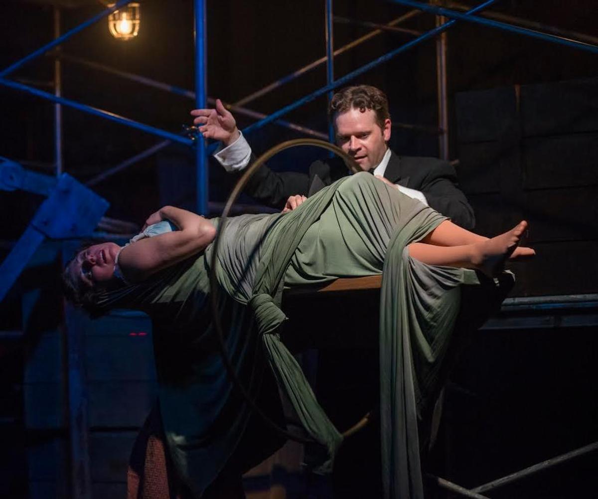 Dennis Watkins as Harry Houdini levitates Emjoy Gavino as the magician’s wife Bess in “Death & Harry Houdini” at the Arsht Center.