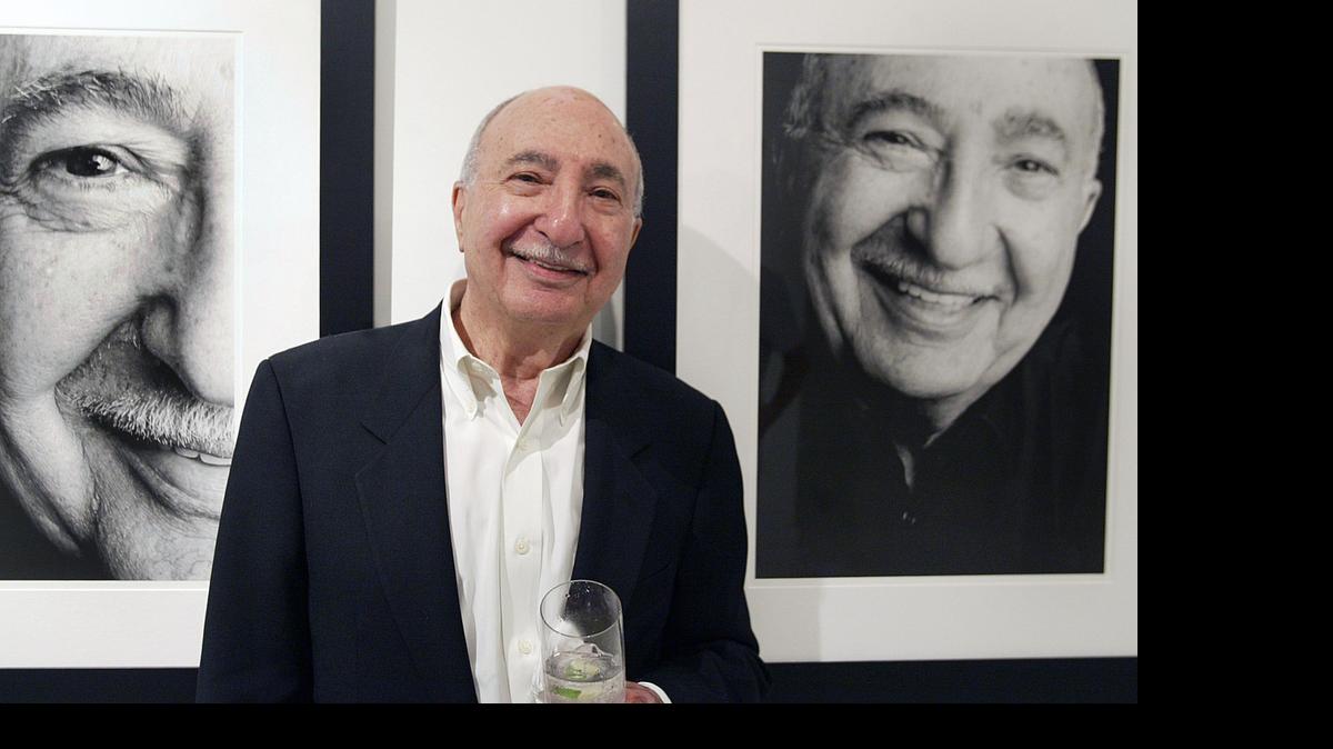 
South Florida press agent Charlie Cinnamon stands near his photo at a 2007 reception for the opening of ‘Like Minds,’ an exhibit by photographer Betty Rosado.
