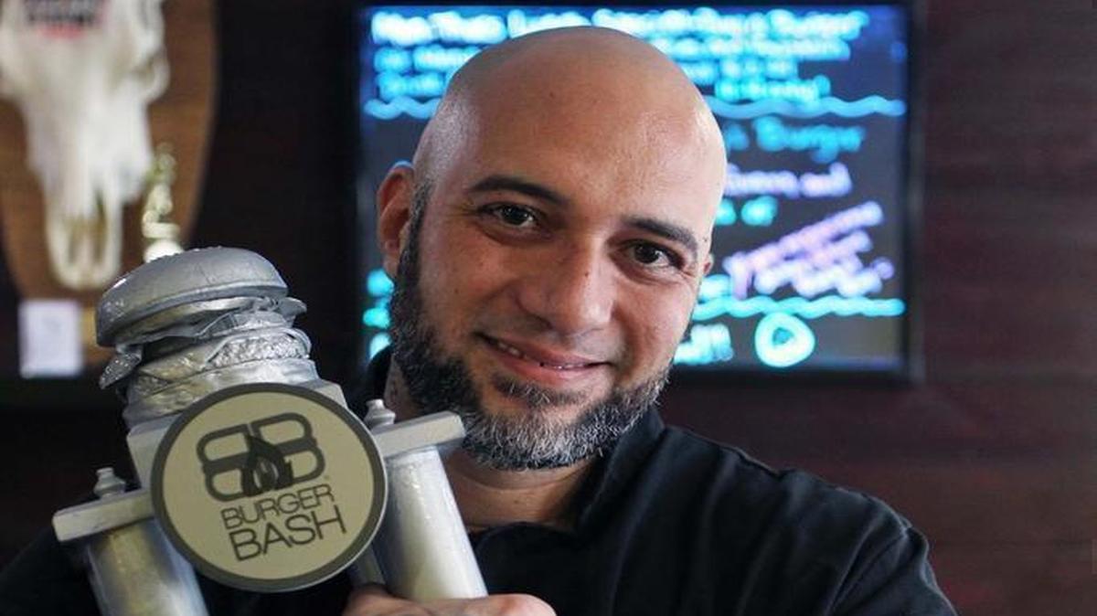Jesus de la Torre Jr. holds his trophy for winning the South Beach Wine & Food Festival’s Burger Bash.