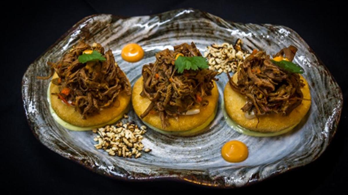 A nod to his Venezuelan upbringing, Antón created a trio of “arepitas,” bite-sized arepas that are made to order, flash fried to crisp the outside while keeping the inside pillowy perfect. These are topped with ropa vieja shredded beef.