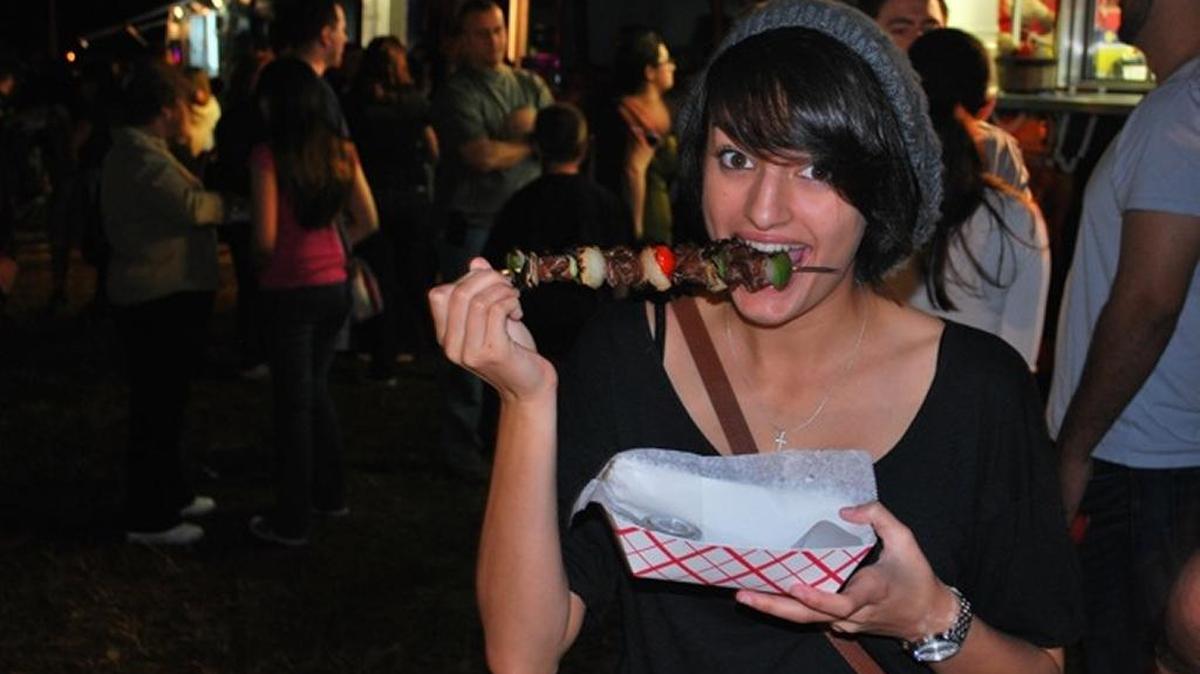 Jessica Medina eats a pinchos skewer from the Daddy's Grill food truck in 2011.