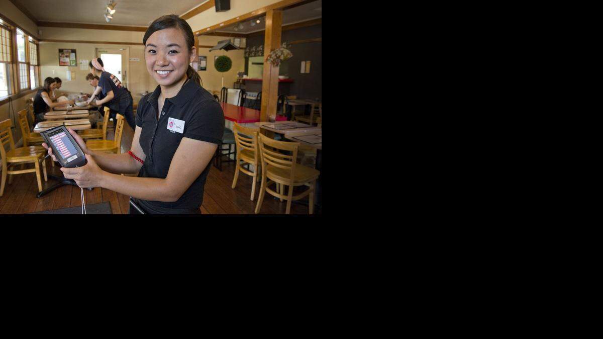 
No pen and paper: Saho Ueyama, manager at Shoki Ramen House in Sacramento, holds a NCR Orderman system that she and staff use to take orders.
