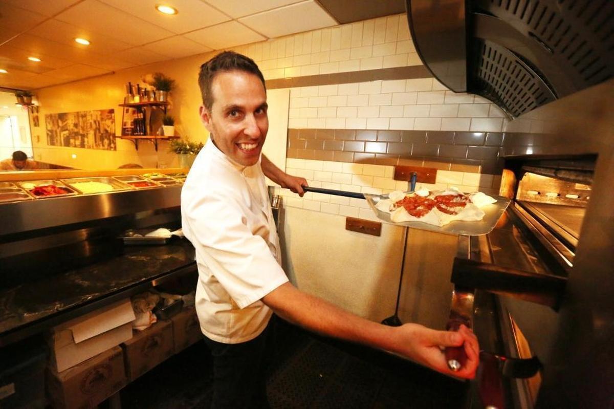 Chef Renato Viola, co-owner of Mister O1, slides a Star Luca pizza, a favorite at the Miami Beach pizzeria, into the oven on Tuesday, March 6, 2018. Viola was an award-winning pizza chef in Italy who gained entry into the United States under an O-1 visa for temporary workers, as an ‘individual who possesses extraordinary ability.’