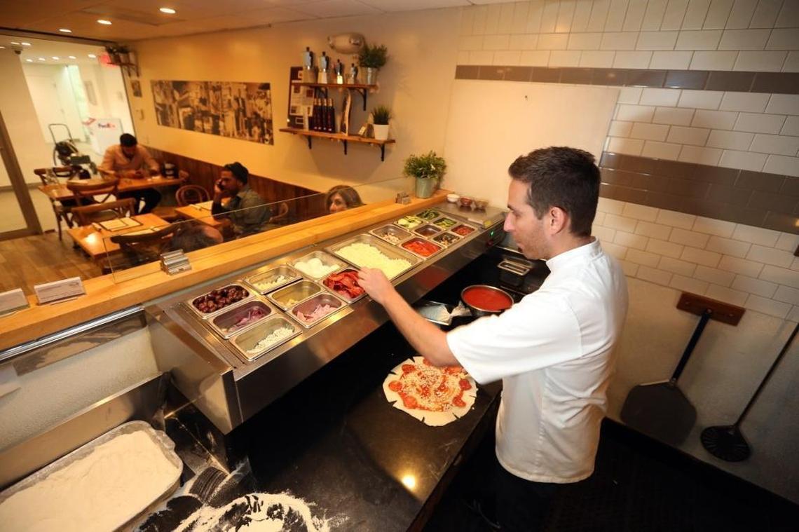 Chef Renato Viola, co-owner of Mister O1 Extraordinary, works on creating a Star Luca pizza, a favorite at the Miami Beach pizzeria, on Tuesday, March 6, 2018. Viola was an award-winning pizza chef in Italy who gained entry into the United States under an O-1 visa for temporary workers, as an ‘individual who possesses extraordinary ability.’ He opened Mister O1 Extraordinary Pizza in Miami Beach, which became a huge hit despite being buried inside an office building with no sign out front. That has led to two other Mister O1 pizzerias, in Brickell and Wynwood in Miami, proving he was indeed an extraordinary pizza chef and entrepreneur.