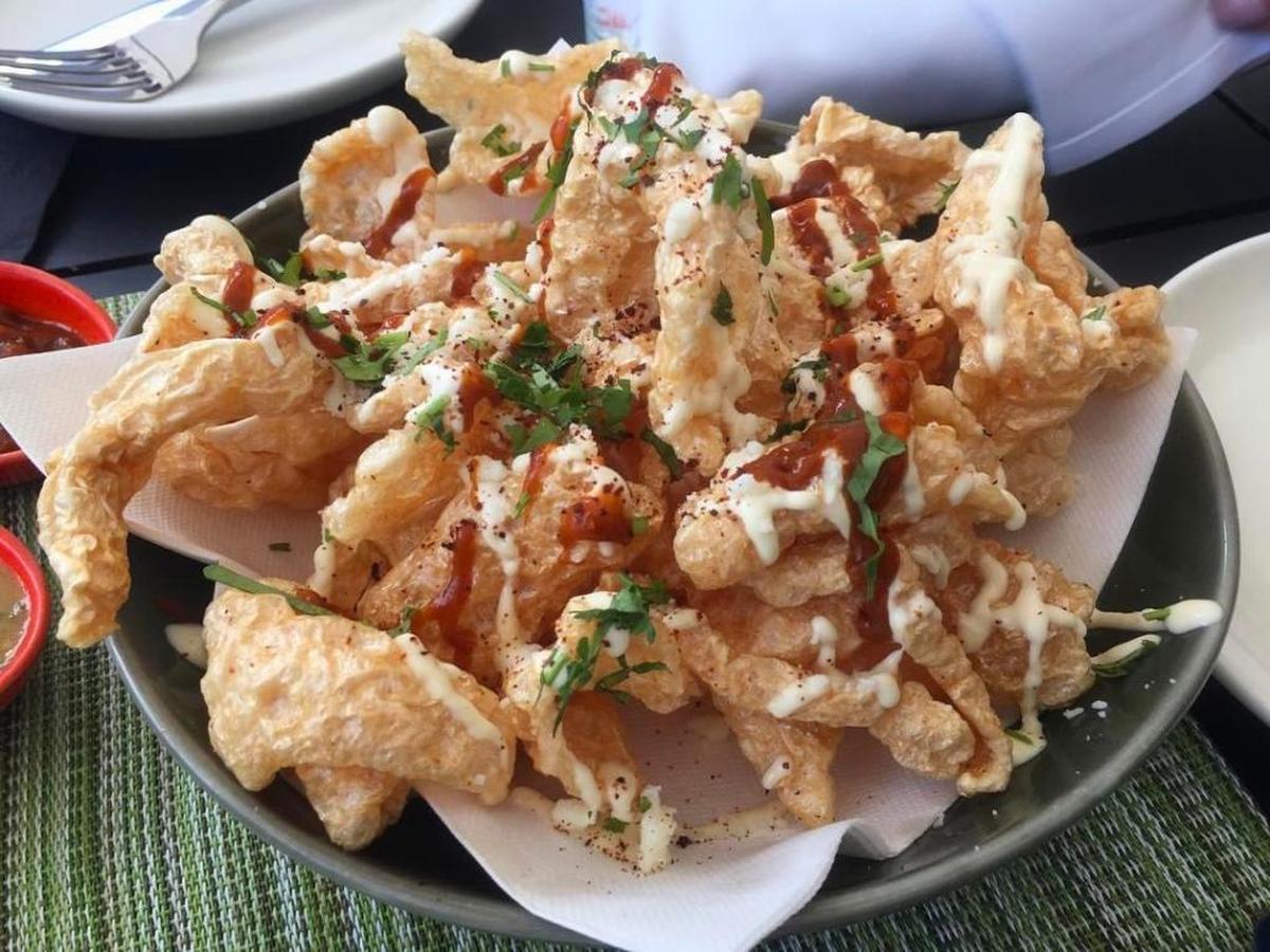 Start with the chicharrones, fried puffed pork rinds drizzled in a finger-licking salsa borracha and garlic mayo.