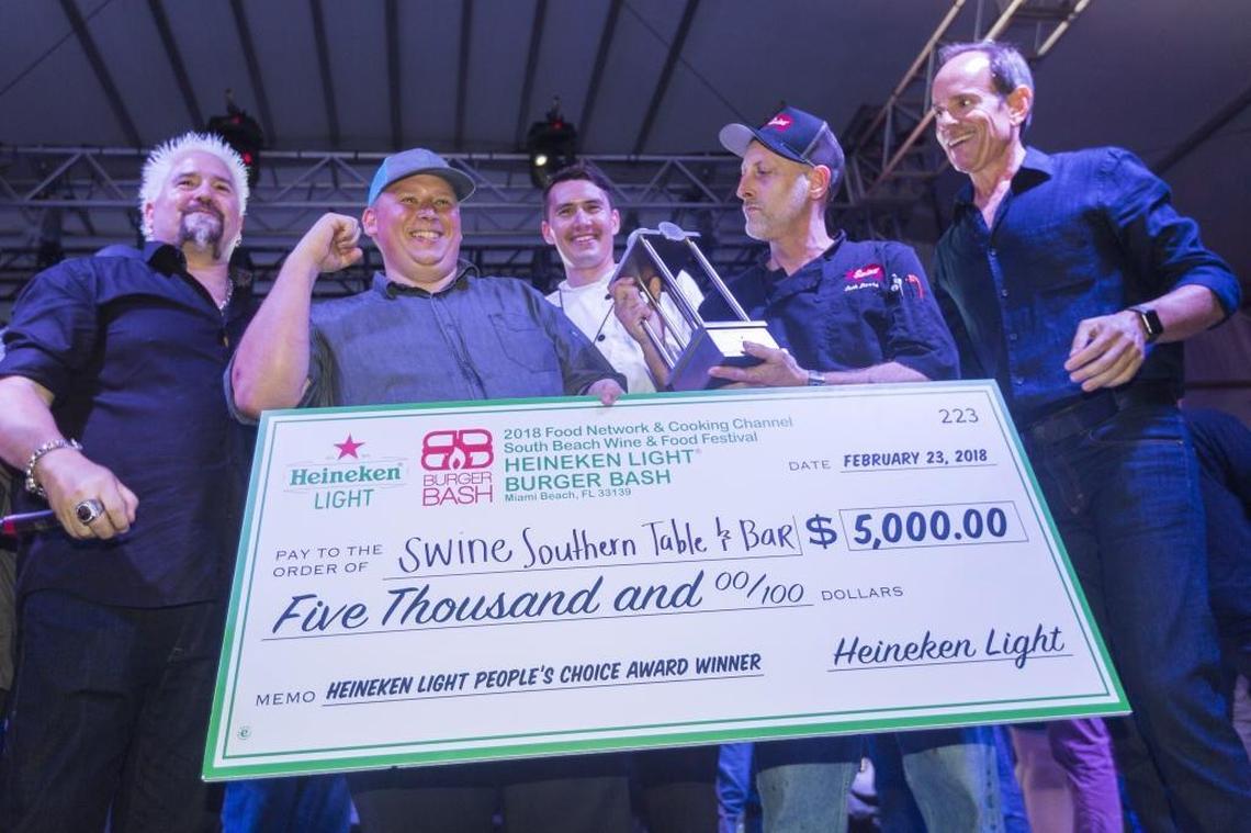Seth Barrs, far right, from Swine Southern Table & Bar, holds his trophy after winning the $5,000 Heineken Light People’s Choice Award during the 2018 South Beach Wine & Food Festival’s Burger Bash in Miami Beach on Friday, Feb. 23, 2018.