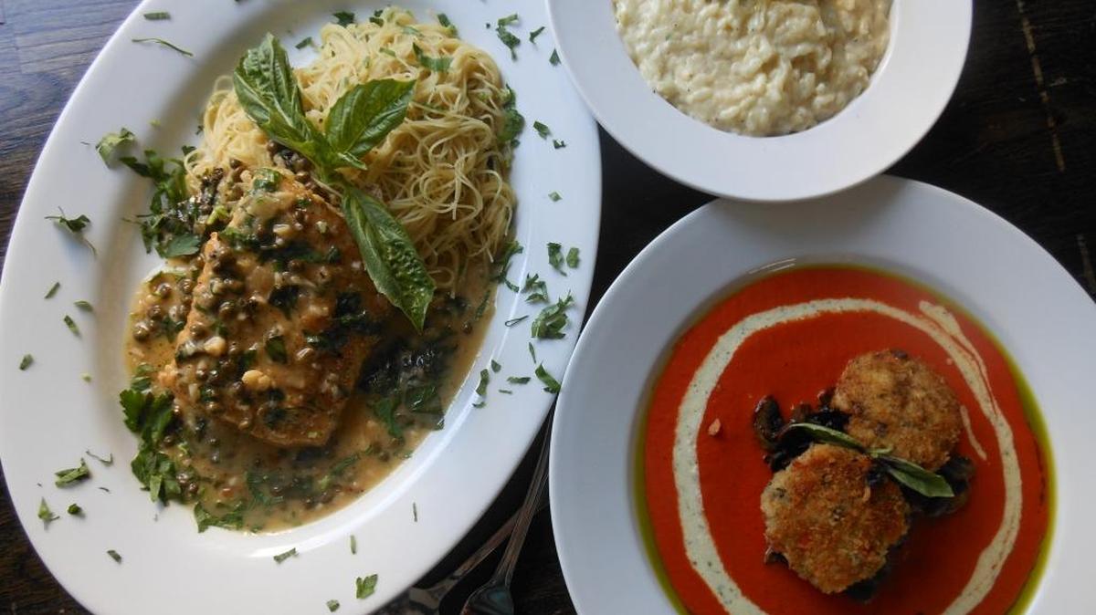 Mahi Frances-style with lemon and capers in white wine-butter sauce, three cheese risotto (parmesan, asiago and mozzarella) and shrimp cakes on sautéed mushrooms in tomato coulis with basil oil served at Crust.