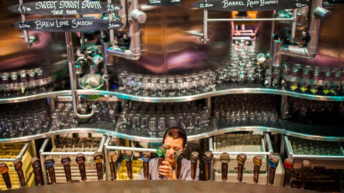 Bartender Morgan Persky pours a pint from one of the 23 beers on tap at Sierra Nevada's taproom in Mills River, North Carolina, on the outskirts of Asheville.