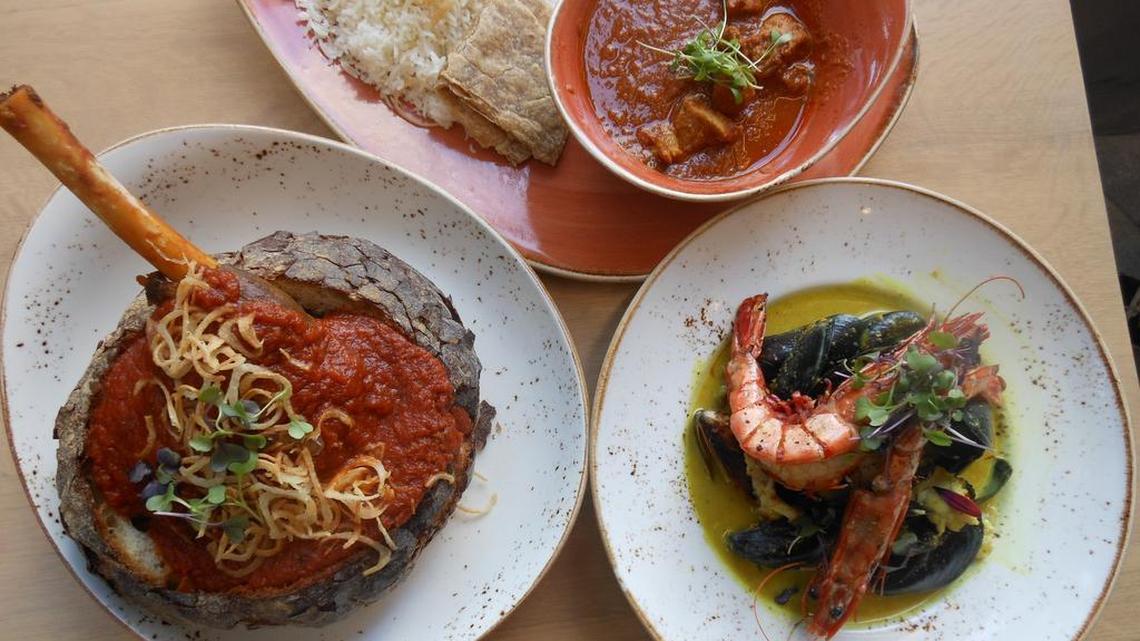 Clockwise from back, angry duck red curry, Cape Malay seafood pot and bunny chow at The Big Easy Wine Bar & Grill, Brickell City Centre.