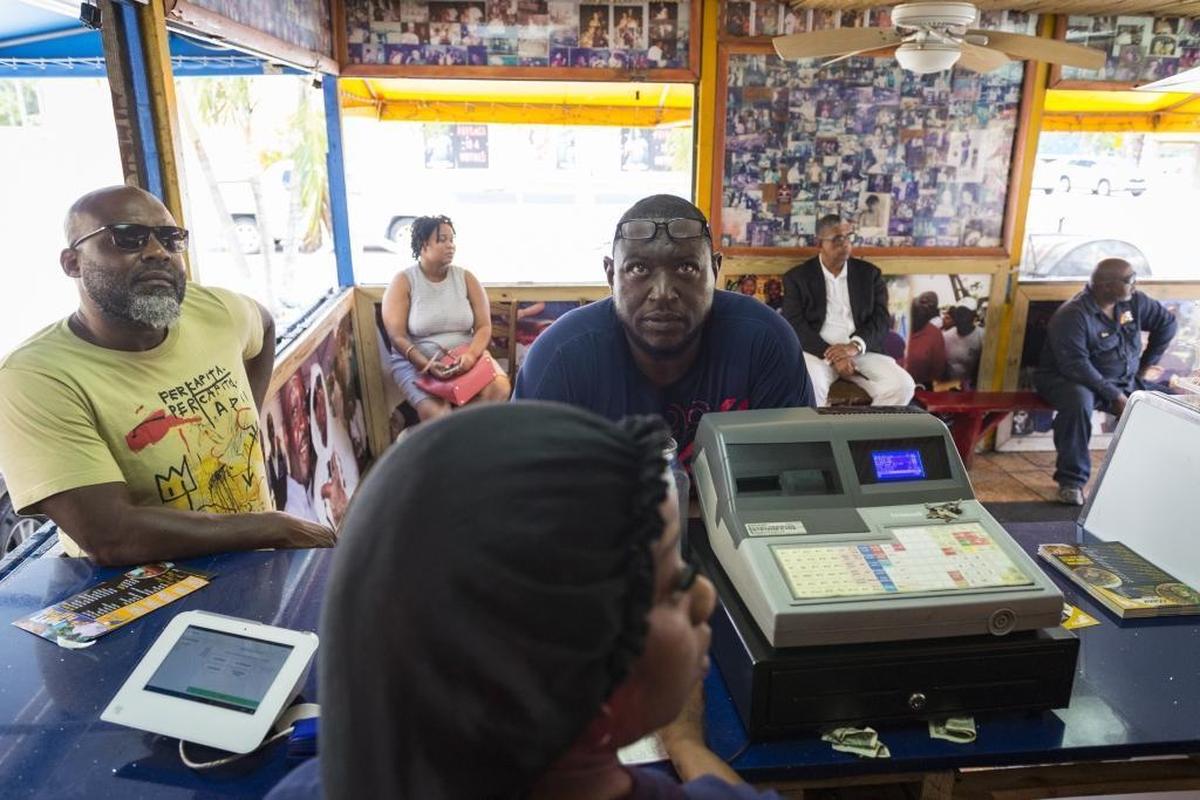 Customers look at the menu as they get ready to order at the Chef Creole restaurant on Northwest 54th Street in Miami on May 23, 2018. The restaurant on 54th street has been known to host people like Anthony Bourdain and many cooking shows. The concept is simple: food is cooked fresh.