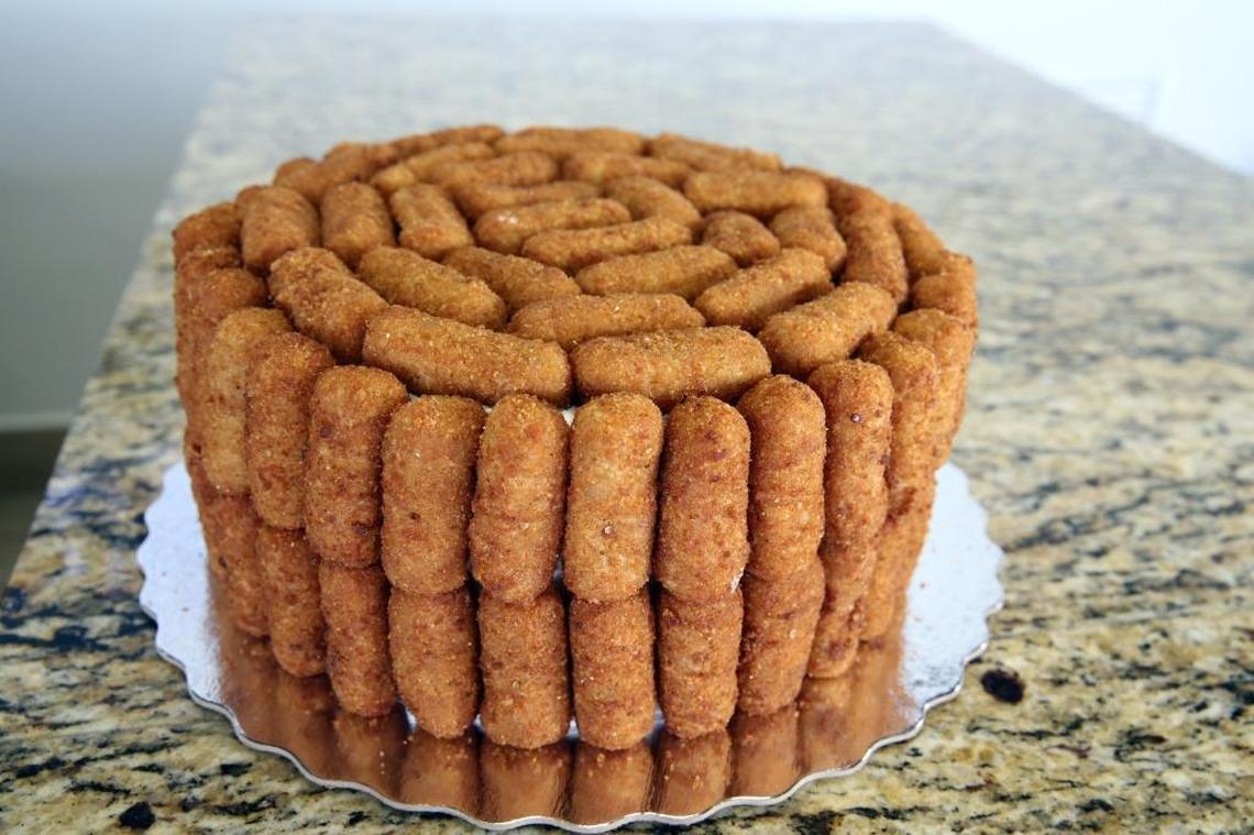 Andy and Jessica Herrera, owners of BreadMan Miami bakery in Hialeah, sell a croqueta cake that is fast becoming a popular item at the bakery. Herrera calls the cake ‘a marvel of engineering,’ as it is built using 100 croquetas and toothpicks, delicately stuck onto the outside of a vanilla cake with whipped icing and Nutella filling.