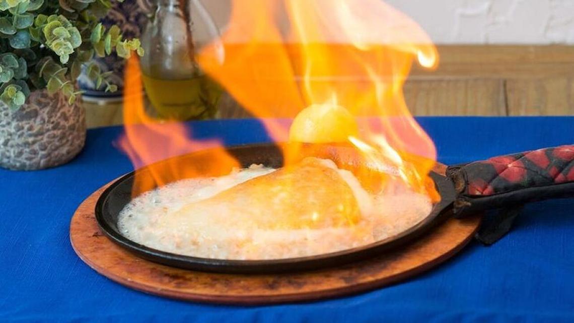 Flaming cheese saganaki ignited with Greek brandy, served as a mezze, is a featured dish at Meraki Greek Bistro in downtown Miami.