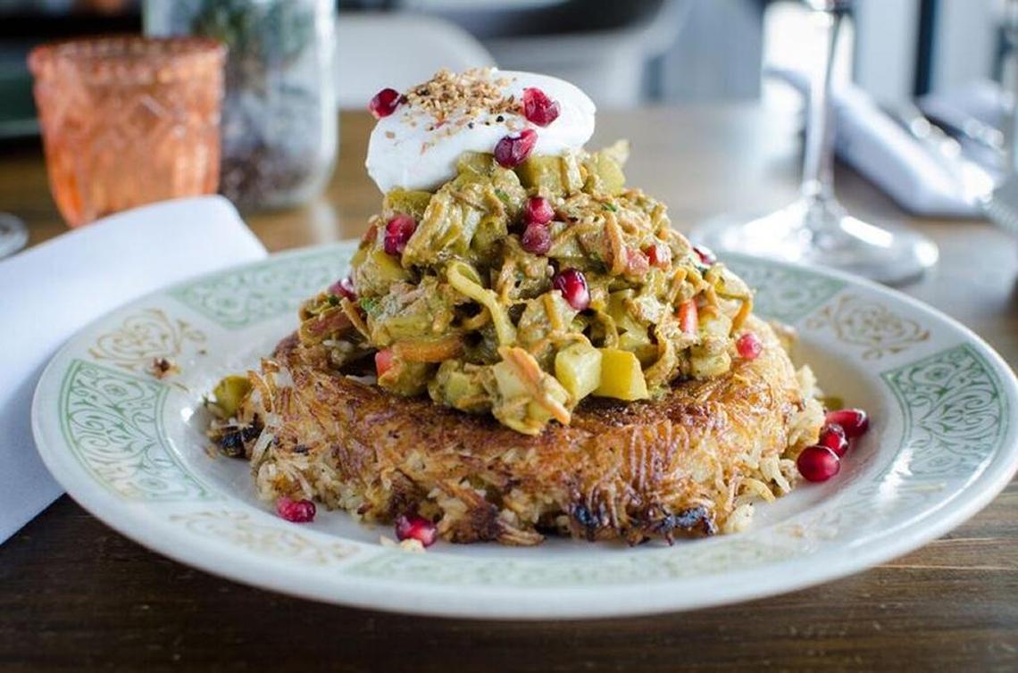 Vegetable khoresh with rice tahdig and pomegranate seeds.
