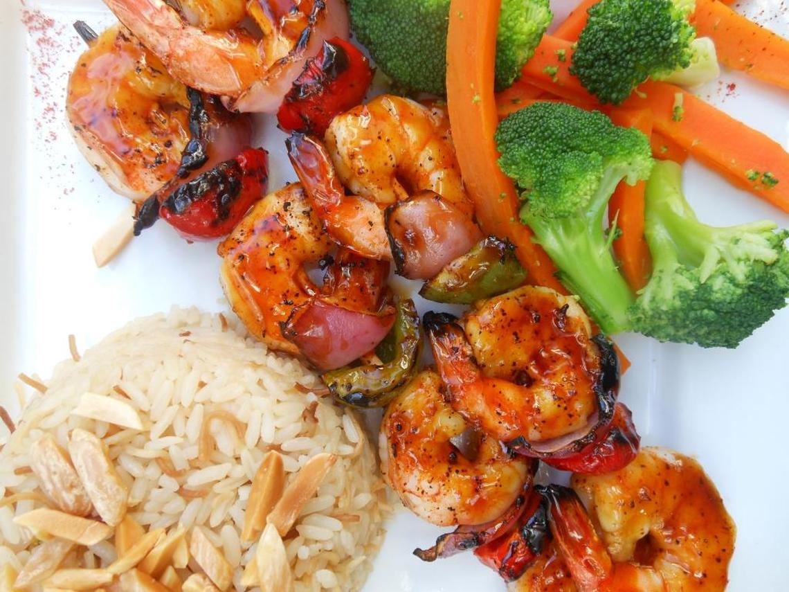 Shrimp kebabs with almond rice and vegetables.