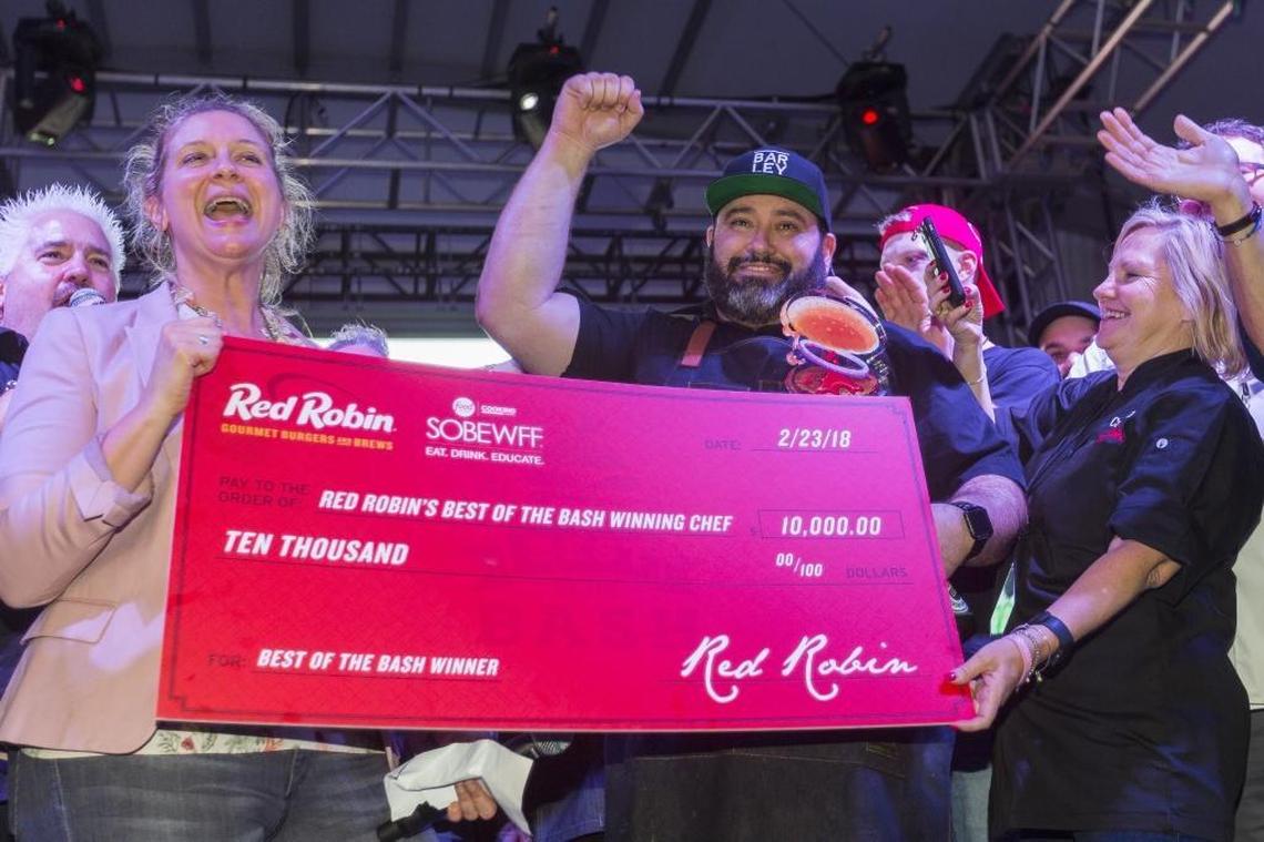 Guy Fieri, far left, presents Barley with the $10,000 Red Robin’s Best of the Bash Winning Chef Award during the 2018 South Beach Wine & Food Festival’s Burger Bash in Miami Beach on Friday, Feb. 23, 2018.