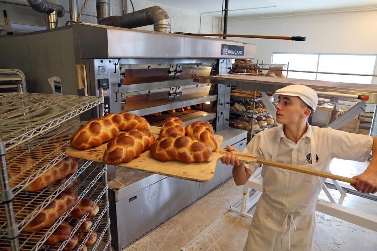 Jimmy Brilhaut, of Zak the Baker, pulls freshly baked challah out of the oven on a Friday morning.