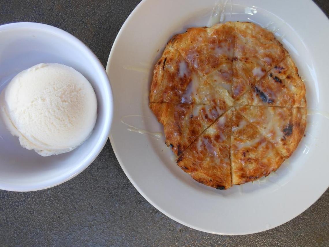 Grilled pastry-like roti drizzled in sweetened condensed milk with a scoop of vanilla ice cream on the side at East Thai Noodle House.