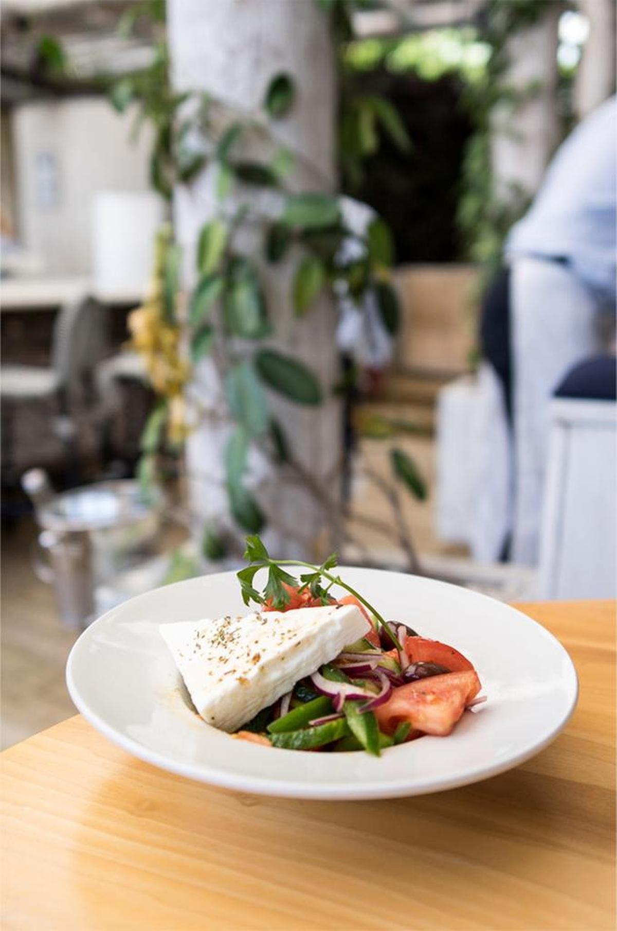 Start with the tomato salad. It features fat, juicy, ruby red tomato quarters, crisp cucumber, red onion, kalamata olives, and a big block of feta cheese, which you crumble yourself as you go.