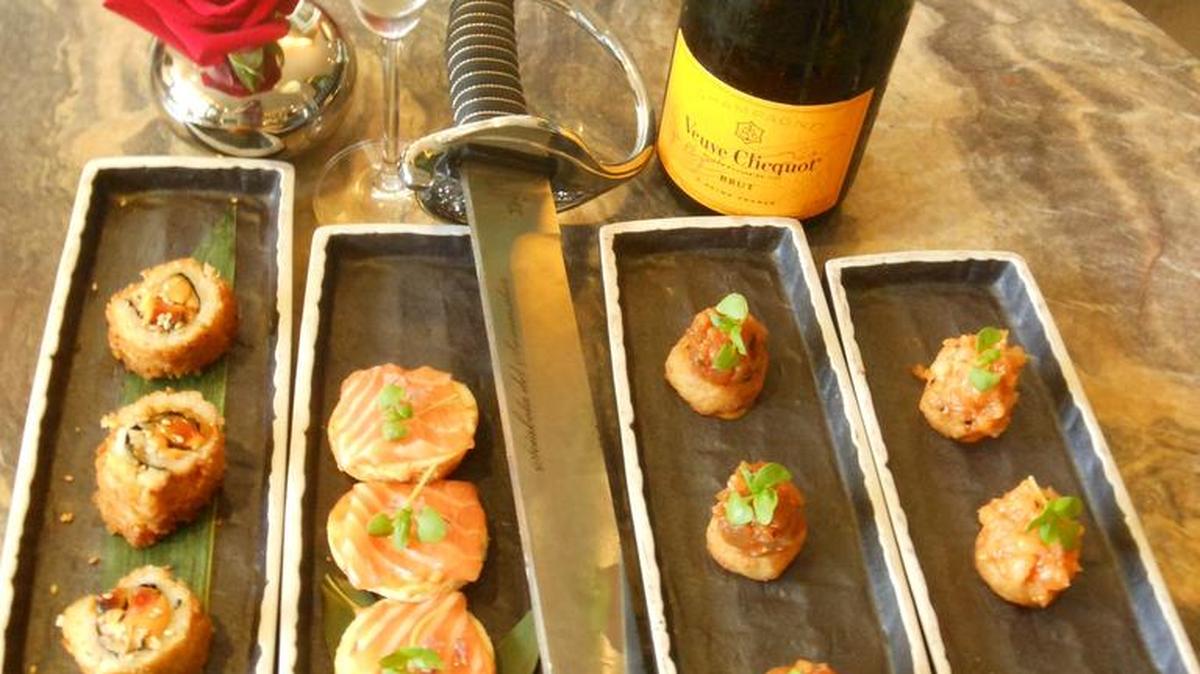 Sushi rolls and smoked salmon ‘pizza’ with a saber and sabered Champagne bottle at the St. Regis sushi lounge, Bal Harbour.