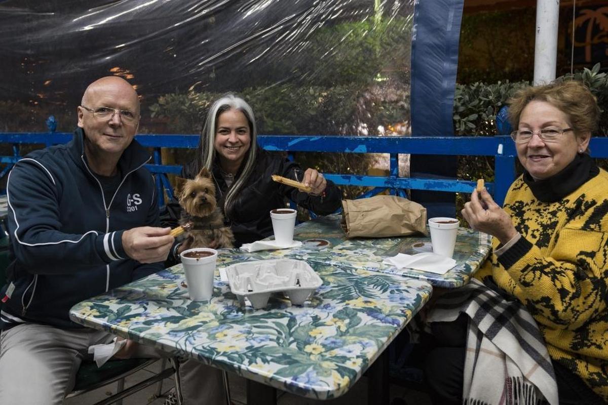 Robert Sicotte, Sara Aviles, and Sara Aviles enjoy their churros and hot chocolate on a night where temperatures dropped to 55 degrees in Miami at La Palma Restaurant on January 3, 2018.