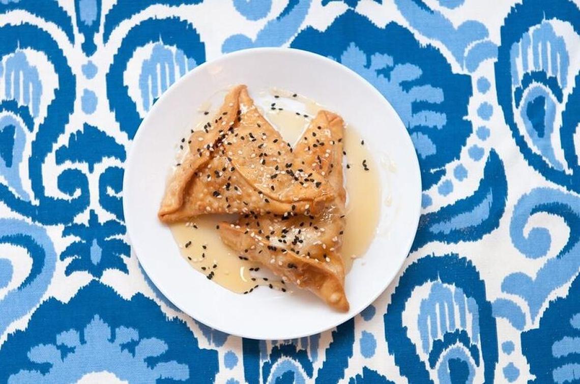 Tiropitakia phyllo wrapped envelopes stuffed with creamy feta sprinkled with sesame seeds and drizzled in honey, a specialty of Crete.