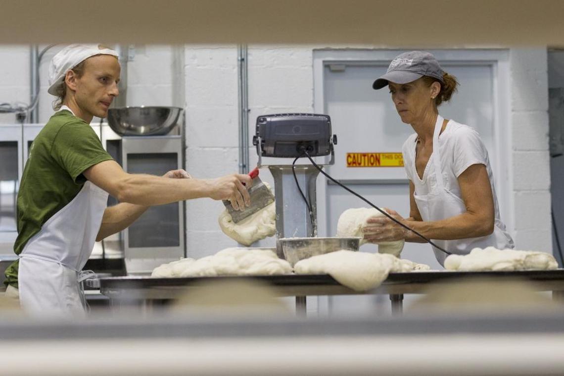 Matthieu Bettant, 35, (left) head baker, and Gail Goetsch, 48, shape bread dough at Sullivan Street Bakery in Little Haiti. Sullivan Street Bakery bread is currently available at several Miami-Dade county restaurants but aims to spread to local grocery stores and markets.