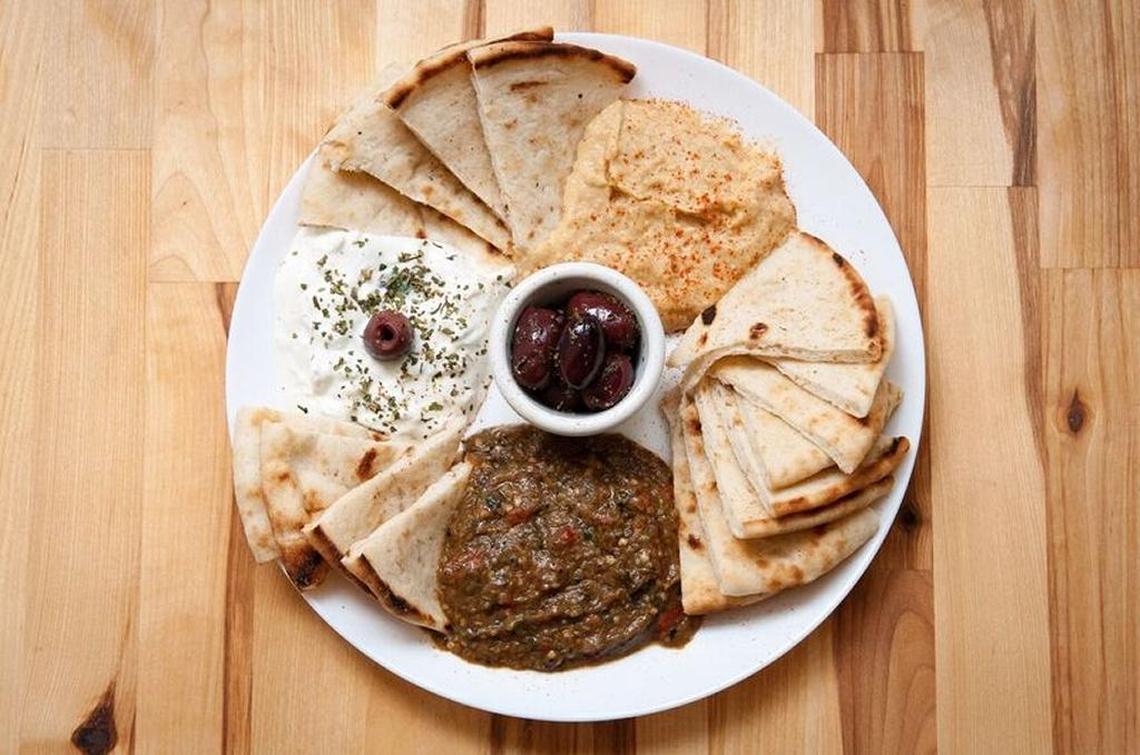The trio of dips including hummus, melitzanosalata (eggplant salad with lemon and garlic) and tzatziki with Kalamata olives and pita.