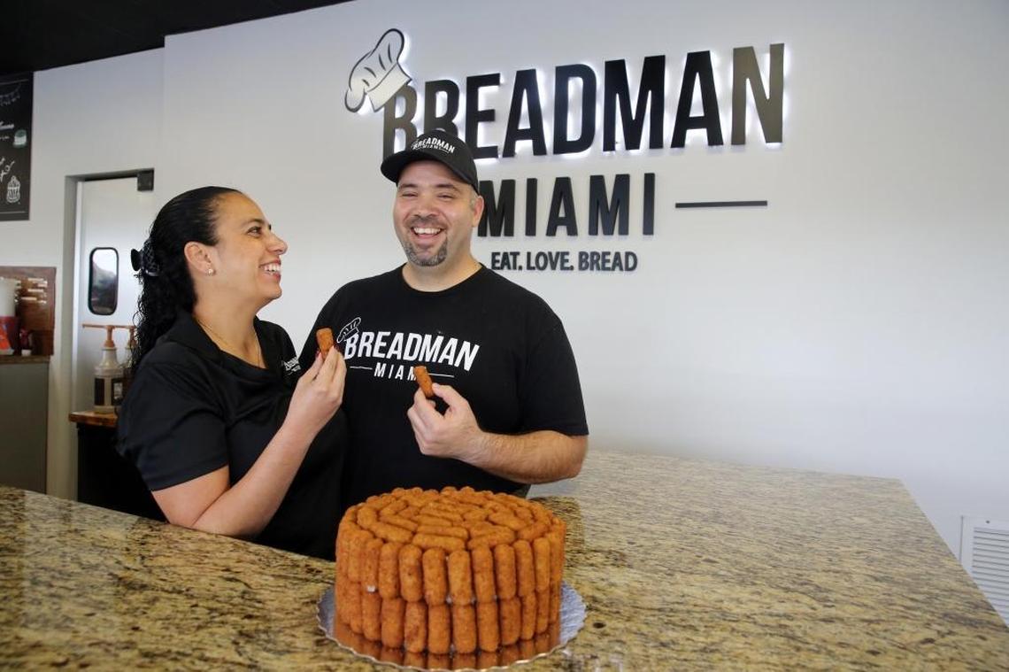 Jessica and Andy Herrera, owners of BreadMan Miami bakery in Hialeah, pull croquetas off of their popular croqueta cake to taste. The unique cake is becoming a popular item at the bakery. Herrera calls the cake ‘a marvel of engineering,’ as it is built using 100 croquetas and toothpicks, delicately stuck onto the outside of a vanilla cake with whipped icing and Nutella filling.