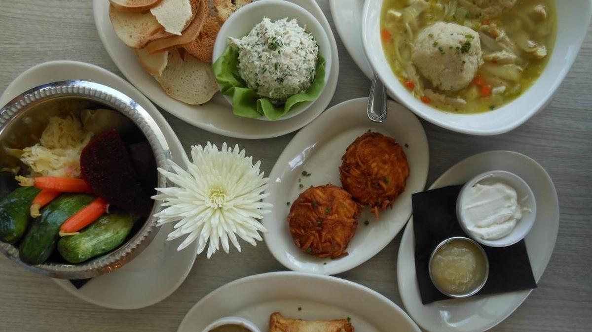 Pickles, whitefish salad with bagel chips, matzo ball soup, latkes with applesauce and sour cream, knish with gravy at Top Hat Deli in Fort Lauderdale.