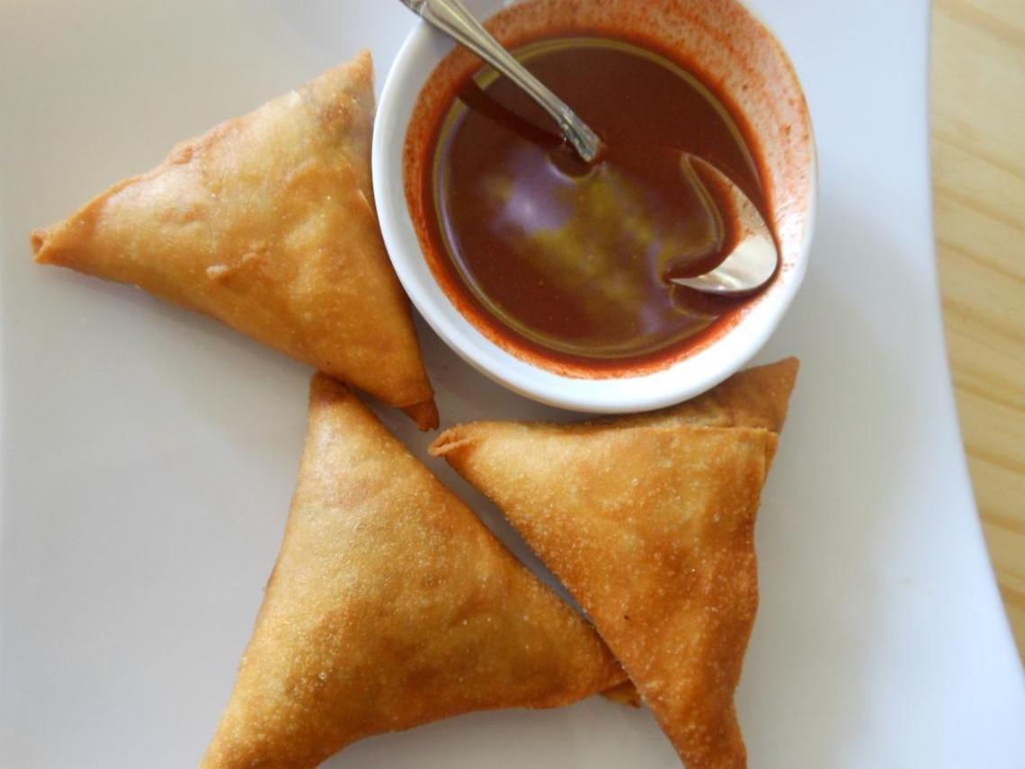Lentil-stuffed sambusa with hot sauce.
