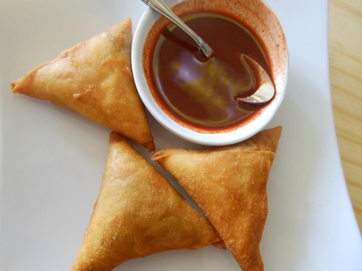 Lentil-stuffed sambusa with hot sauce.