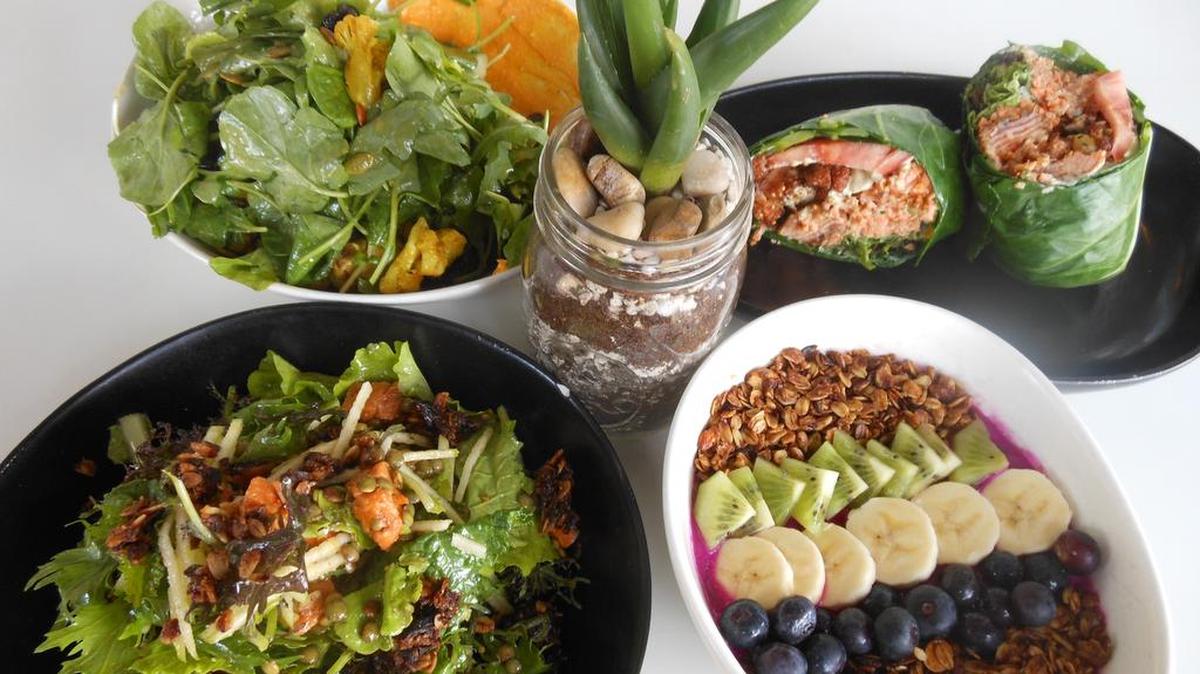 Salads, a salmon po' boy in a collard leaf wrapper and granola bowl with dragon fruit puree and fruit served at Dirt, Miami Beach.