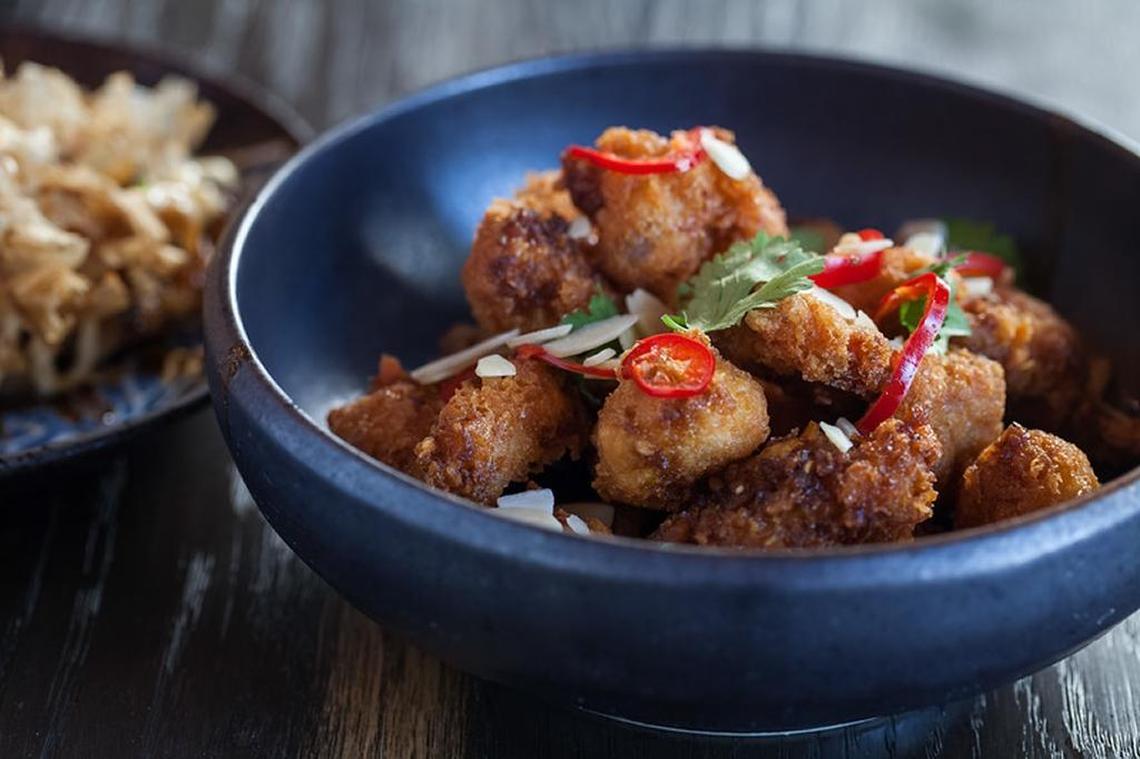 The classic takeout dish, kung pao chicken, goes high society, with large cubes of chicken, smoked cashews, sweet orange segments and cilantro.