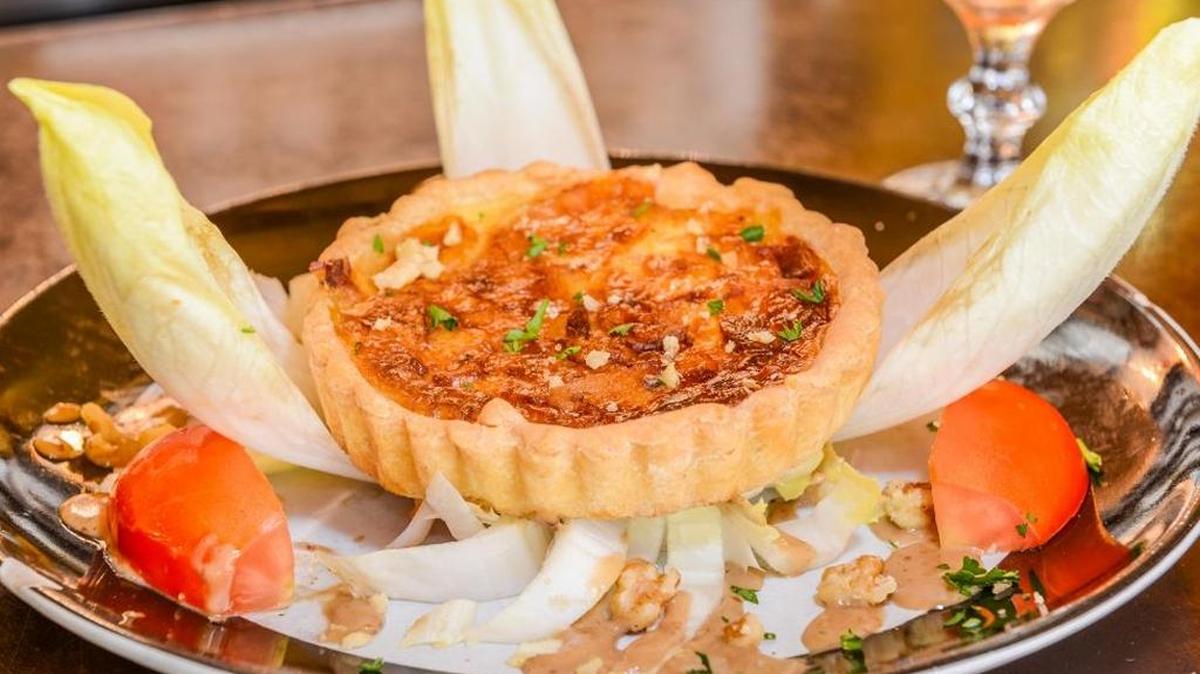 Start with a wedge of quiche Lorraine with bacon, served over a bed of endives, walnuts and tomatoes at A La Folie.